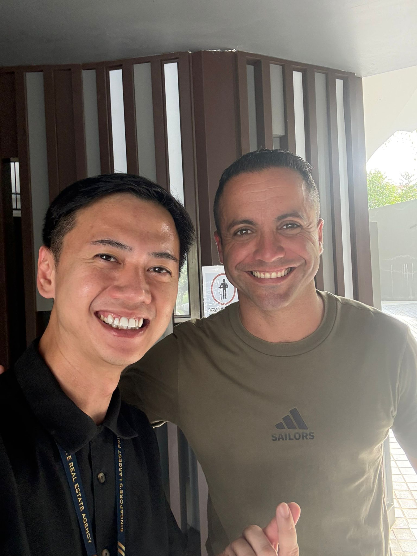 Fendy Lee taking a selfie with a client, smiling in a bright indoor setting